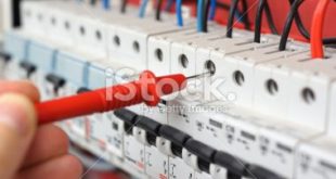 Electrician's hand with multimeter probe in electrical cabinet of Royal cabinets ...